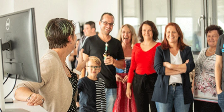 Besucher*innen des family day lachen bei Rundgang durch das Büro.