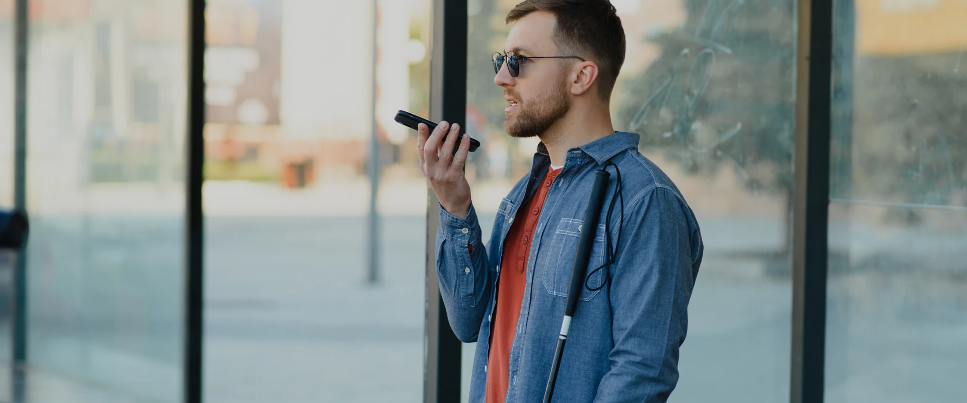 Ein Mann hält ein Smartphone in der Hand und bedient es mittels Spracheingabe